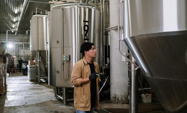 A modern industrial facility with stainless steel tanks, pipelines, and automated machinery. The setting showcases a clean and well-organized environment, highlighting advanced processing and manufacturing operations.